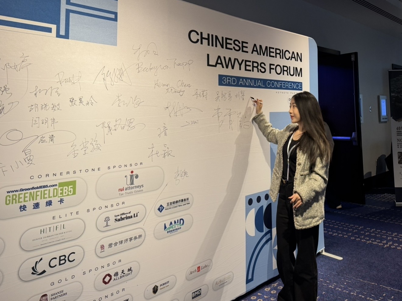 Dolly Xinyu Hu at the signature wall of the 3rd Chinese American Lawyers Forum.
